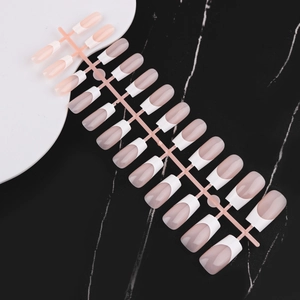 Macro shot of 24 pieces french nude false nails with white tips on marble background