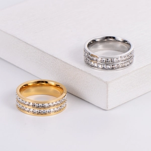 Polished double-row zircon eternity rings in gold and silver on stone display