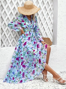 Détail de robe longue fleurie à col en V, manches longues et découpe à la taille en bleu