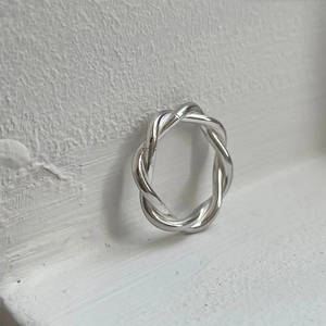 Close-up of a 925 sterling silver twisted rope ring with high-polished texture