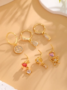 Close-up of 18k gold plated nose studs with zircon butterfly and smiley patterns