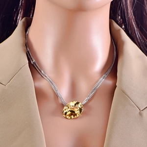 Detailed view of bicolor layered necklace featuring a gold textured heart pendant on a model