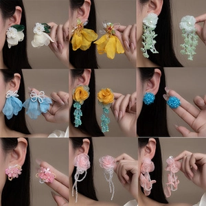 Detail view showing nine styles of fabric floral earrings and beaded drop jewelry