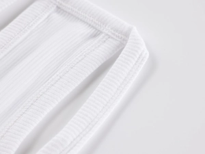 Close-up of white ribbed knit fabric texture with durable double-needle stitching detail