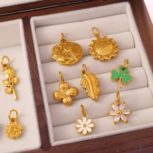 Golden flower and clover charms with enamel in a velvet jewelry box