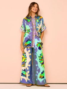 Detail of tropical fruit and floral print on smooth satin wide-leg pants and shirt set