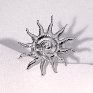 Top view of silver sun ring featuring a spiral center and wavy rays with hammered texture