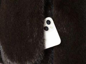 Détail de la poche de veste en fausse fourrure marron foncé et texture peluche