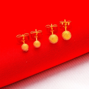 Gold plated brass ball earrings with frosted matte finish on red and white background