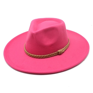 Dettaglio di un cappello fedora magenta in feltro di lana con nastro intrecciato marrone