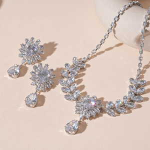 Détail de la parure collier et boucles d'oreilles argentées avec fleurs en zircon