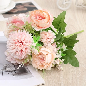 Close-up of artificial flower bouquet with pink roses and daisies on a wooden desk