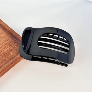 Close-up of polished black acetate hair claw with glossy finish and sturdy teeth