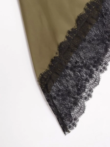 Détail de couture sur tissu en satin vert olive et dentelle noire délicate sur l'ourlet