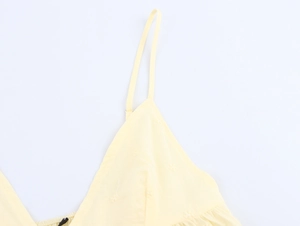 Macro shot of delicate floral embroidery on light yellow camisole top and shorts set