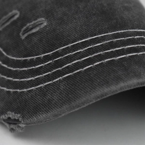 Detail of white contrast stitching and distressed edge on washed cotton baseball cap