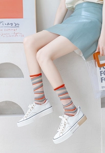 Rainbow striped mid-calf socks styled with white platform shoes and light blue skirt