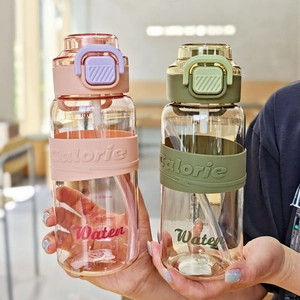 Detail of pink and green plastic sports water bottles with silicone sleeves and straw lids