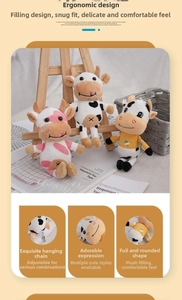 Dettaglio di simpatici portachiavi a forma di mucca in peluche con catene in metallo