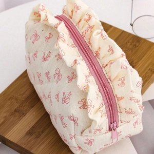 Pochette trucchi trapuntata panna con fiocchi rosa e dettagli decorativi a balze