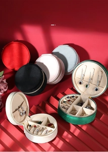 Mini circular jewelry box with zipper, featuring necklace hooks and multi-compartment storage