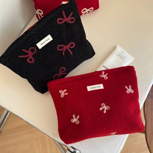 Detail of red and black bow embroidered cosmetic bags with elegant simple wish woven labels