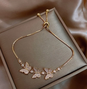 Detailed view of gold butterfly bracelet with white zircon pavé and adjustable slide clasp