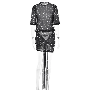 Detail view of black polka dot mesh dress with sheer fabric and back tie design