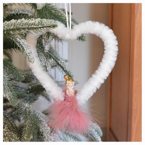 Close-up of white plush heart ornament with a pink feather angel on a snowy Christmas tree
