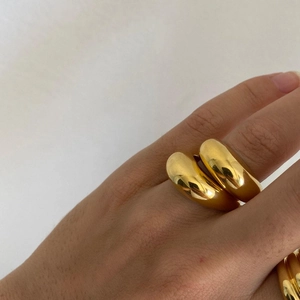 Close-up of dual chunky gold-plated dome rings with high-polish mirror finish