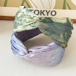 Détail de bandeaux larges en satin avec des motifs botaniques verts et tie-dye violets