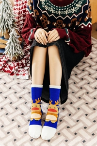 Detail of plush royal blue Christmas sock featuring a cute reindeer pattern and white fluffy cuff