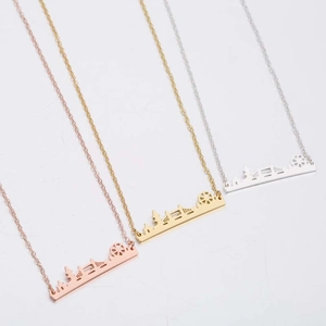 Detailed view of urban skyline necklaces in rose gold, gold, and silver finishes