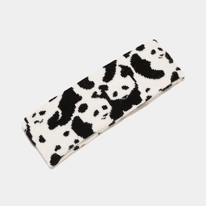 Close-up of knit headband featuring black and white panda patterns for winter warmth