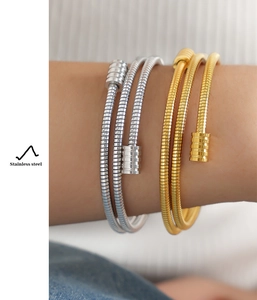 Detail of multi-layered stainless steel snake chain bracelets in gold and silver finish