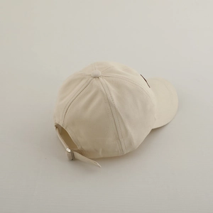 Detail of adjustable metal buckle and stitching on beige cotton twill baseball cap