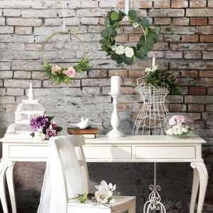 Floral iron ring wall decor featuring pink and white silk roses on a vintage brick background