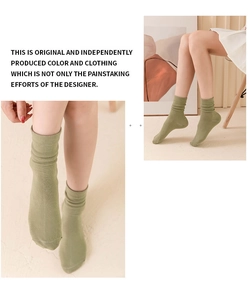 Detail of olive green knitted slouch socks showing fine cotton texture and loose fit