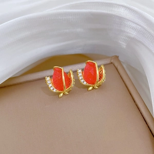 Detail of gold floral stud earrings with red gem center and sparkling crystal petals