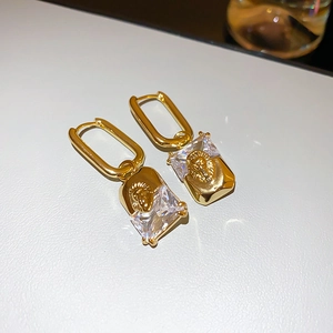 Detail of vintage lion head earrings with gold plating and square-cut crystal