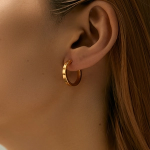 Minimalist 18K gold plated brass hoop earrings featuring a polished smooth finish on model