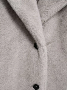 Detailed close-up of grey faux fur coat collar and texture with elegant button detail