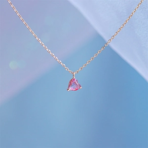 Macro shot of 18k gold plated pink heart zircon pendant with refined three-prong setting