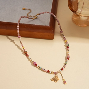 Detail view of a beaded necklace with multi-colored beads and a golden butterfly charm