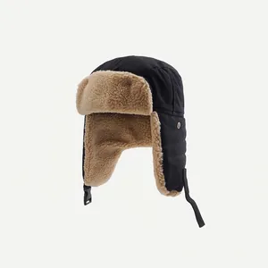Close-up of black winter trapper hat with warm beige faux fur lining and adjustable strap