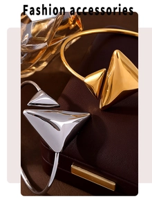 Macro detail of gold and silver geometric triangle bangles on leather jewelry box