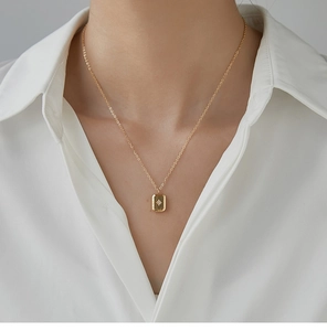 Detail of 18K gold plated necklace featuring a rectangle pendant with starburst star