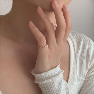 Minimalist gold pearl ring shown on model finger with elegant white pearl detail