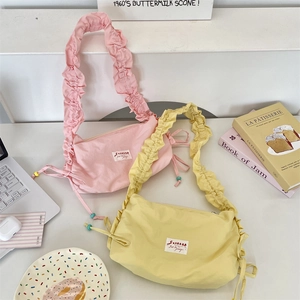 Detailed view of pink and yellow pleated ruffle shoulder bags with drawstring design