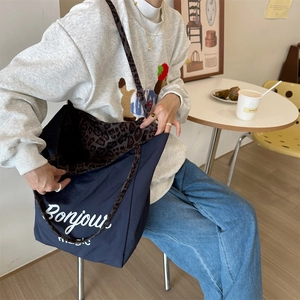 Detailed view of dark blue tote bag showing its large capacity and leopard print lining